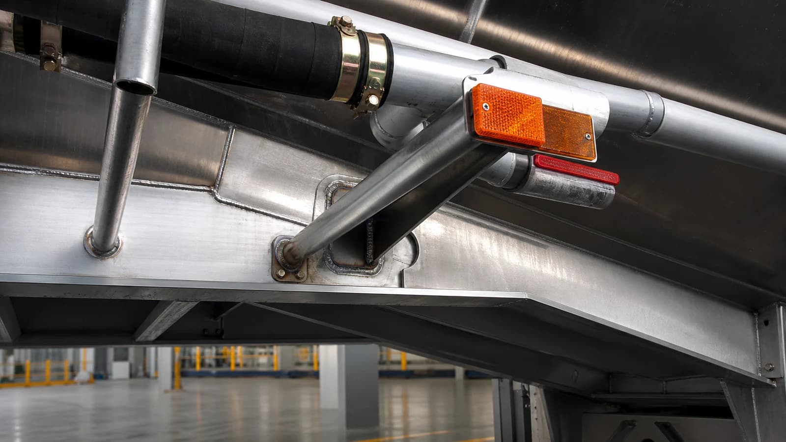 T-section main beam where it meets the underbody, showing the welded connection that carries the load